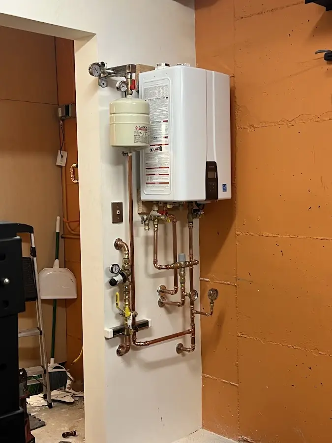 Plumbing technician inspecting water heater connections in Wade Hampton